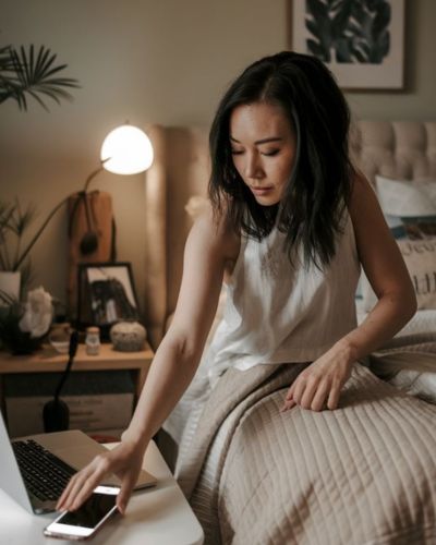 Mujer usando el celular antes de dormir en la cama