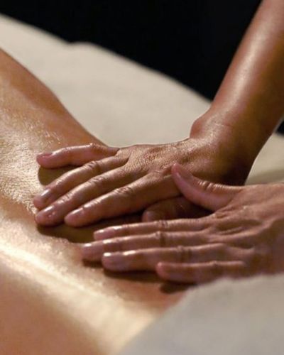 Masaje terapéutico en la espalda con aceite corporal aplicado con ambas manos, ayuda con la mastitis.