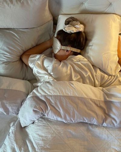 Mujer durmiendo de lado con antifaz y ropa cómoda