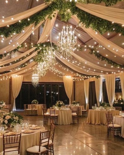 Decoración de boda elegante con luces cálidas y telas en el techo