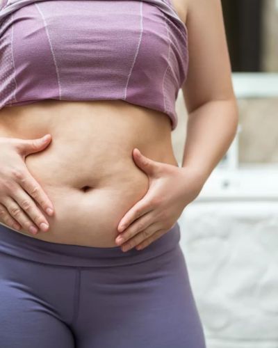 Mujer tocando su abdomen como referencia a la salud física y bienestar