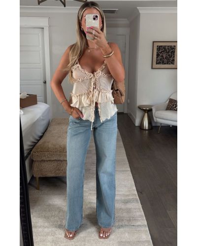Los jeans rectos y una blusa ligera son piezas perfectas para combinar sandalias nude 