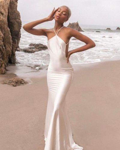 Futura esposa posando en la playa con vestido corte sirena en color marfil