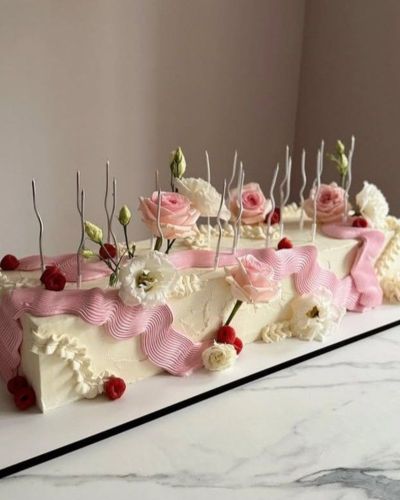 Pastel de cumpleaños rectangular en color blanco con detalles rosados y verdes