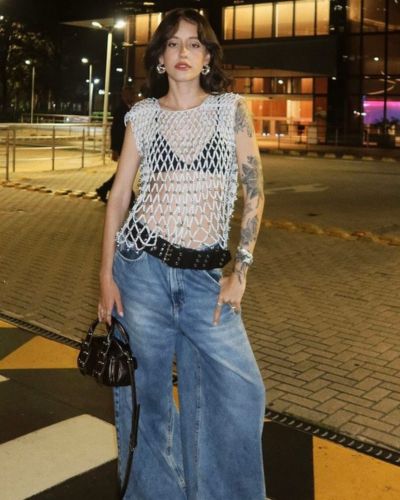 Look con jeans anchos, bralette negro y top sin mangas tejido
