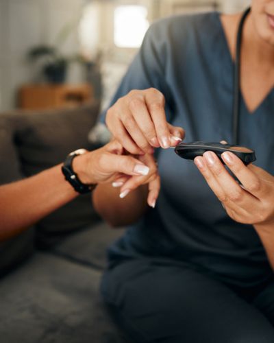 Profesional de salud toma la glucosa capilar con un glucómetro durante una consulta.
