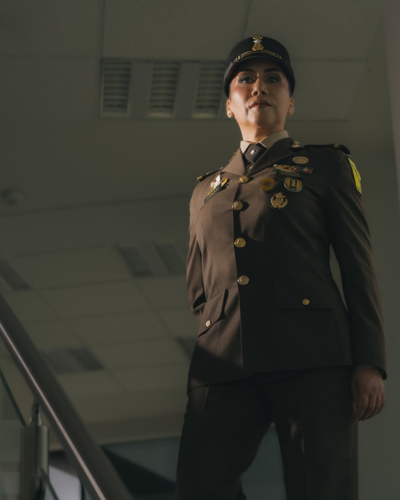 Mujer en uniforme militar en escaleras dentro de un edificio institucional; imagen para nota sobre liderazgo femenino en el Ejército Mexicano.