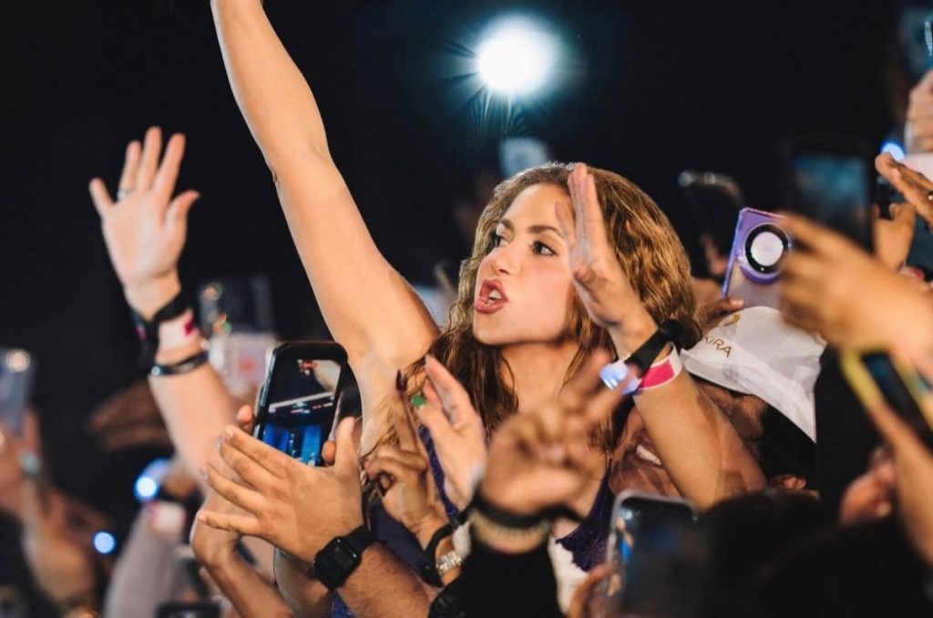 Shakira canta entre la multitud durante su concierto en el Zócalo de la Ciudad de México, rodeada de fans que la graban con sus celulares.