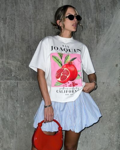 Modelo viste falda globo en color azul, camiseta gráfica oversized en color blanco.