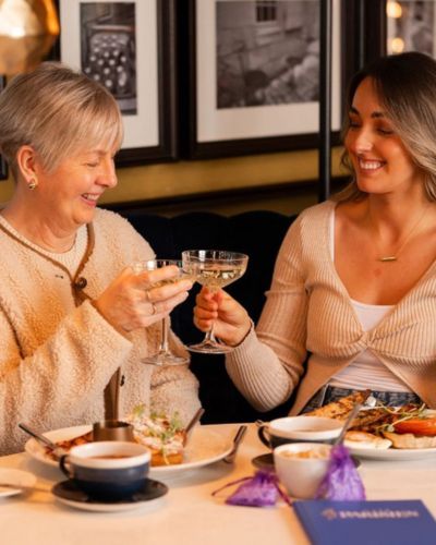 Foto de madre e hija disfriutando del 10 de mayo, Día de las Madres en un restaurante