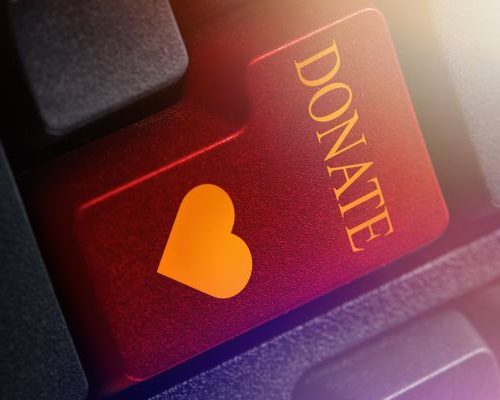 Tecla de teclado con la palabra “DONATE” y un ícono de corazón, símbolo de apoyo a la donación de células madre.