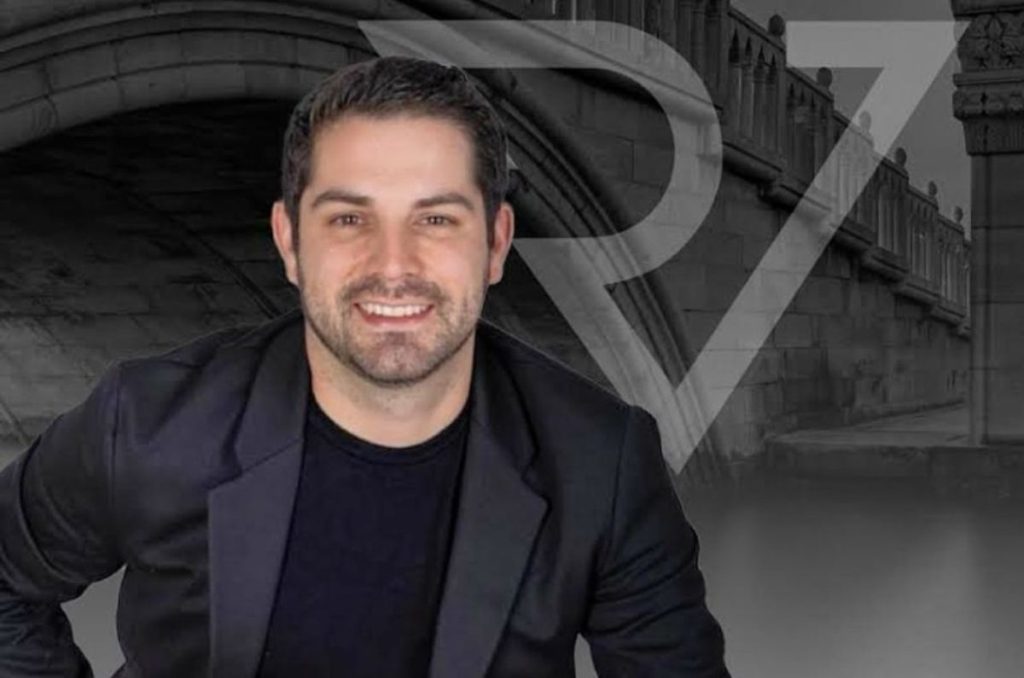 Foto del Dr. Rafael Vizcaino con saco negro, sonriendo frente a fondo gris.