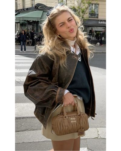 Modelo portando usando una bomber jacket y una bolsa Miu Miu