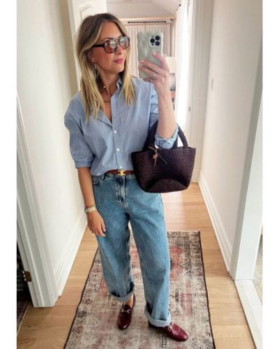 Modelo viste mom jeans, camisa azul y mocasiones rojos.