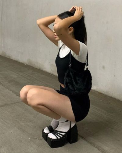 Modelo con little black drees, blusa blanca de mangas cortas, calcetas blancas y sandalias negras