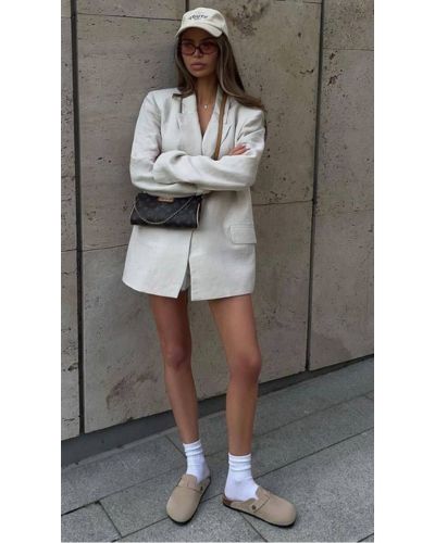 Mujer urbana con clogs de ante y blazer"