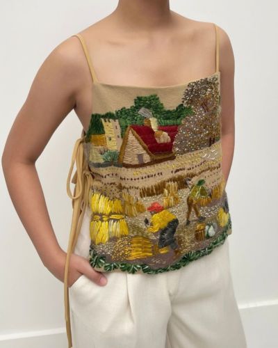 Cómo combinar prendas bordadas: blusa con bordados de colores y pantalones blancos.