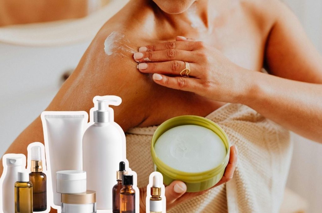 Mujer aplicando crema corporal en el hombro mientras sostiene un tarro de producto, acompañada de envases de skincare, como parte de una rutina para lograr una piel suave, hidratada, luminosa y bien cuidada.