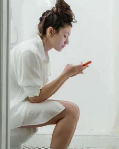 Foto de mujer usando el teléfono en el baño 