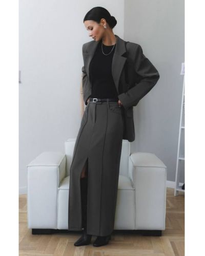Outfit para mamás con falda sastre en color gris, top negro, blazer corto gris y botas vaquetas negras.