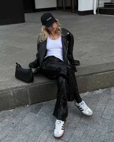 Outfits en pareja para ver a Harry Styles: pantalón de lentejuelas color negro, top básico blanco, chaqueta de cuero, gorra, bolso negro y tenis blancos