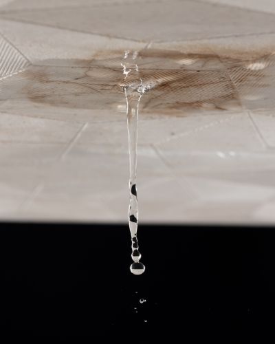 Gotas de agua cayendo del techo con mancha de humedad, señal de filtración activa durante la temporada de lluvias.