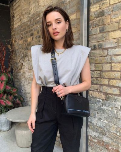 Look con pantalón negro, top gris claro y bolsa cross body