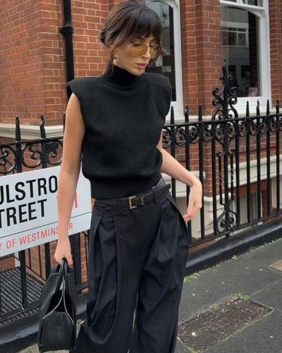 Total look negro con jeans negros y top con hombreras