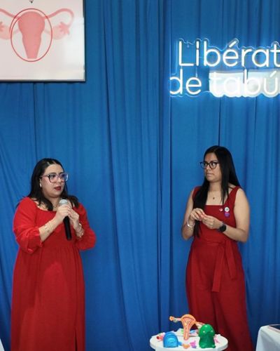 Dos mujeres en un escenario con fondo azul y letrero “Libérate del tabú”, durante una actividad del Festival Ciclo M 2026 enfocada en salud menstrual.