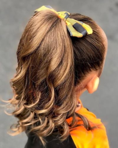 Niña con un corte de cabello moderno y un peinado práctico para el regreso a clases 2026