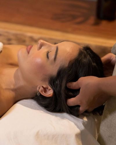 Mujer realizando un spa capilar en casa con inspiración japonesa, aplicando un tratamiento capilar y masajeando el cuero cabelludo para nutrir, relajar y fortalecer el cabello desde la raíz.