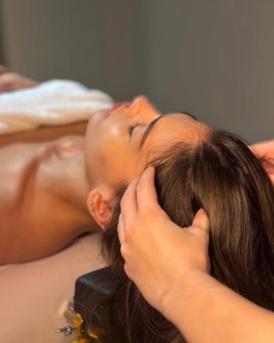 Mujer realizando un spa capilar en casa con inspiración japonesa, aplicando un tratamiento capilar y masajeando el cuero cabelludo para nutrir, relajar y fortalecer el cabello desde la raíz.